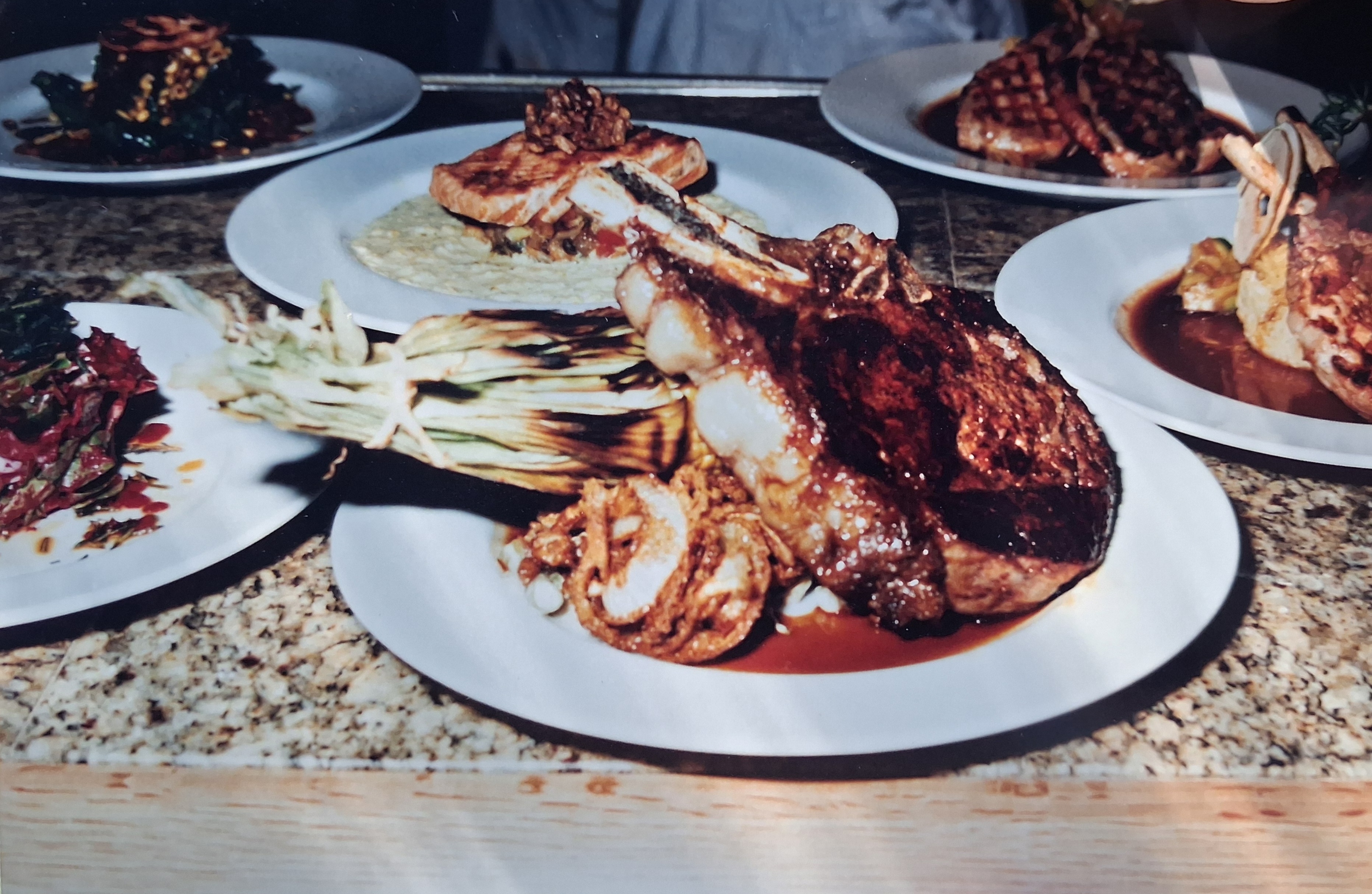 Grilled ribeye surrounded by other plated dishes.